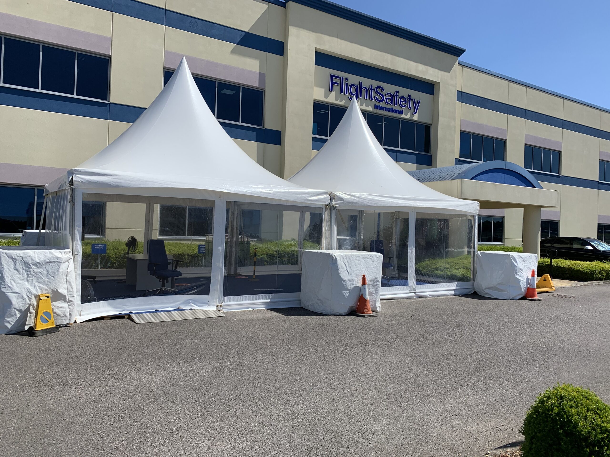 White pagodas providing covered outdoor space at a corporate event venue
