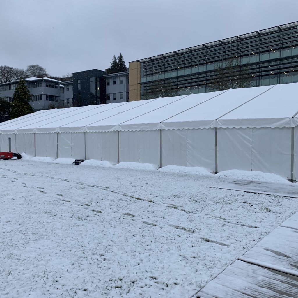 Large temporary frame marquee installed on a snow-covered site for winter events, corporate functions or temporary facilities.