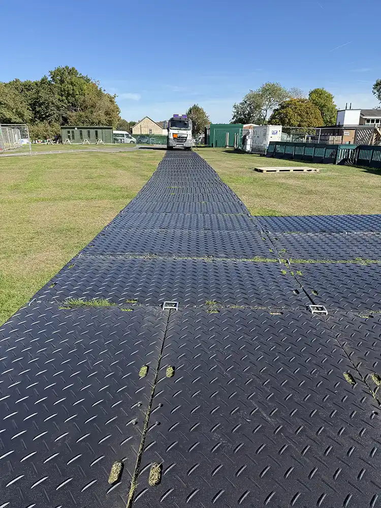 Temporary roadway trackway panels installed on grass for vehicle access to marquee site